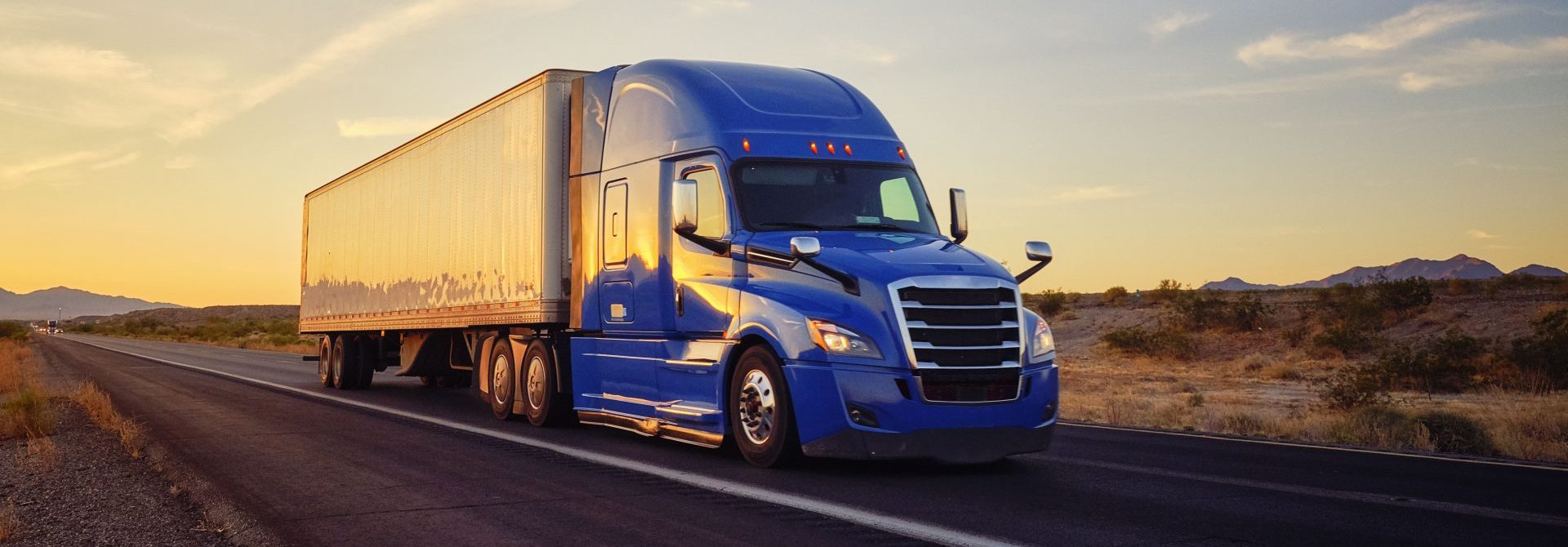 Blue truck parked during sunset