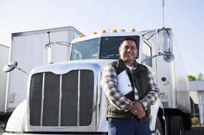 Man in a vest posing in front of a white truck