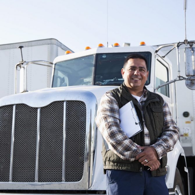 Man in a vest posing in front of a white truck